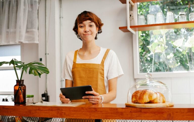 A woman standing behind the counter of a café.