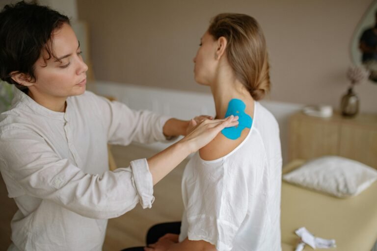 A woman practicing physical therapy on a patient.